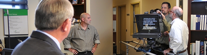 A picture of a man reading from a TelePrompter.